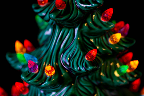 Albero di Natale in ceramica con luci colorate su sfondo nero - foto stock