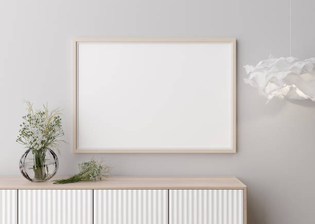istock Empty horizontal picture frame on white wall in modern living room. Mock up interior in minimalist, contemporary style. Free space for your picture. Console, flowers in vase, lamp. 3D rendering. 1412307835