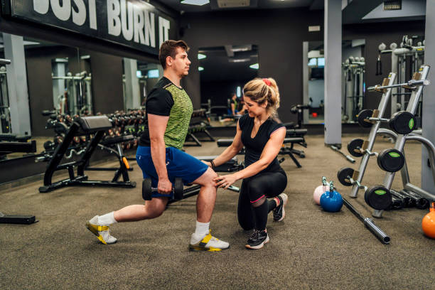 istock Fitness trainer assisting a man in the exercise 1412307930