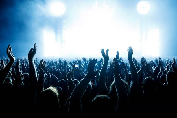 actuación de un grupo popular. la multitud con las manos levantadas contra la luz del escenario. - vida nocturna fotografías e imágenes de stock