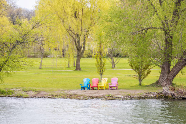 istock Colorful Adirondack chairs by a lake 1412314608