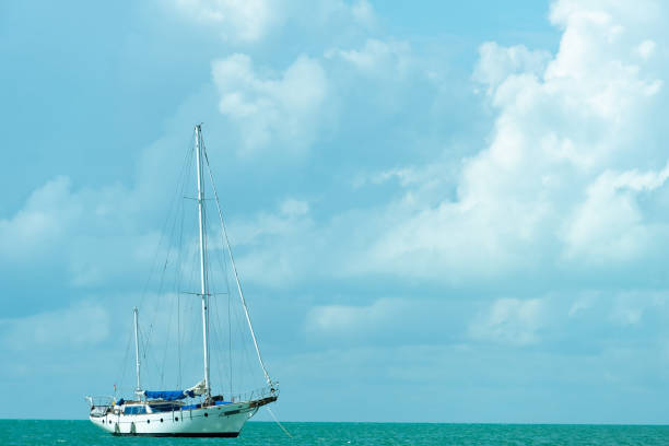 istock A yacht with a lowered sail against a cloudy sky. White sailboat on turquoise waves. Copy space. 1412317813