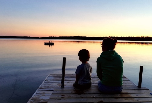 Mother and son on the dock at sunset