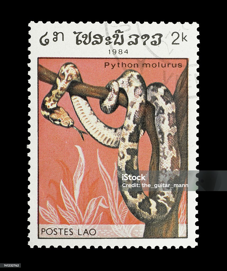 indian python Mail stamp printed in Lao featuring an Indian python snake wrapped around a tree, circa 1984 Animal Stock Photo