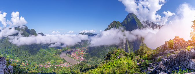 View from the top Viewpoint of Nong Khiaw - a secret village in Laos. Stunning scenery of limestone cliff valley covered with green rainforest jungle mysterious clouds