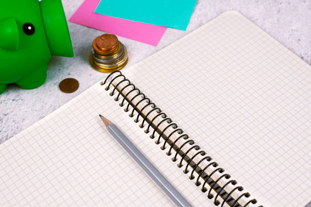 Important Message On Notebook On Desk With Money, Pen, Notes And Pig Box.