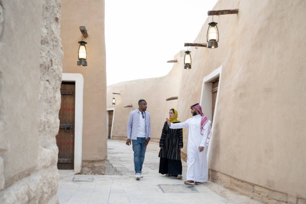 istock Saudi guide and tourists walking through heritage site 1412330766
