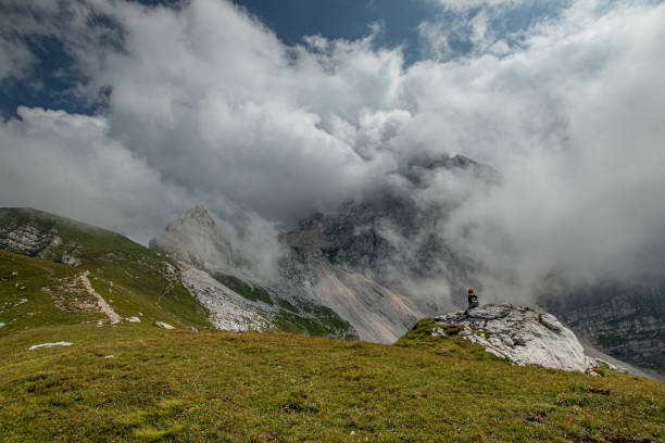 istock Human sitting on the rock in mountains 1412331168