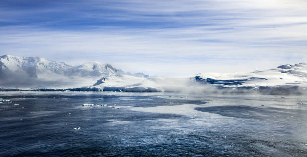 Patterns in the sea water add visual interest to this panoramic view of mountains in Fournier Bay, Antarctica.