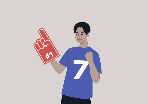 A young male Asian team supporter waving a foam finger, sports competition