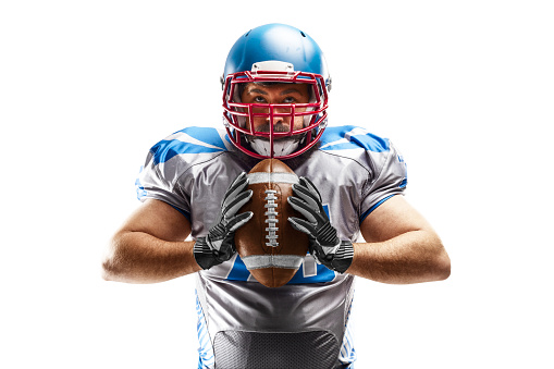 Sport closeup. Young american football player holding the ball in his hands. American football. Sport