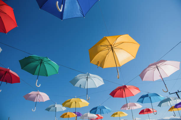 coloridos paraguas de fondo. paraguas de colores en el cielo. decoración de calles. composición de arte conceptual. - umbrella decoration fotografías e imágenes de stock