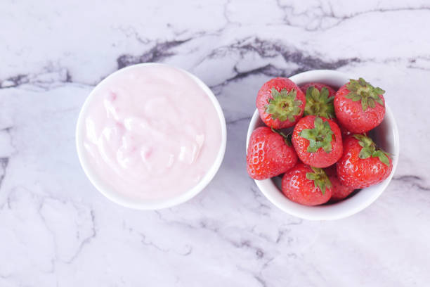 istock Yogurt and strawberry in a bowl on white 1412349162