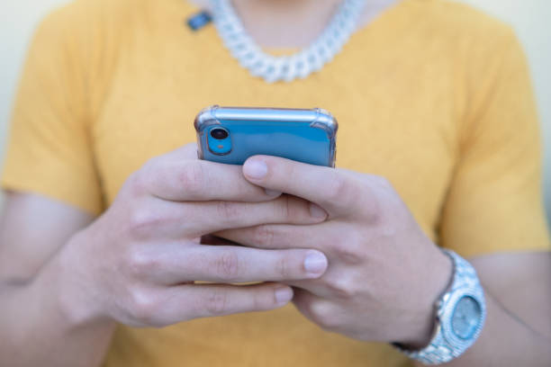 istock Closeup of happy young man using modern smartphone device - Hipster guy typing sms message on phone - Selective Focus 1412351294