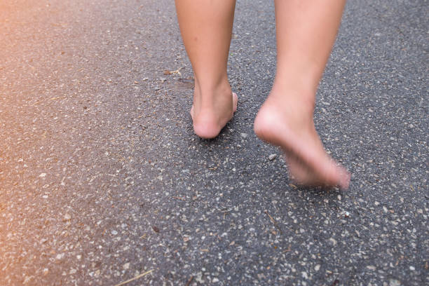 istock Two feet walking on the street. With barefoot 1412358615