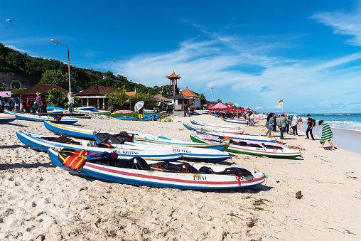 Bali, Indonesia - March 28, 2019: View of canoes and tourists at Pandawa beach. Pandawa Beach Bali is a white sand beaches in southern Bali located in Kutuh Village, Badung Regency.