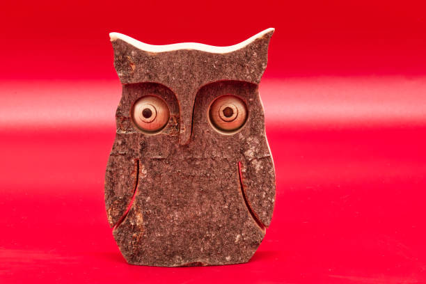Wooden Owl isolated on red background.