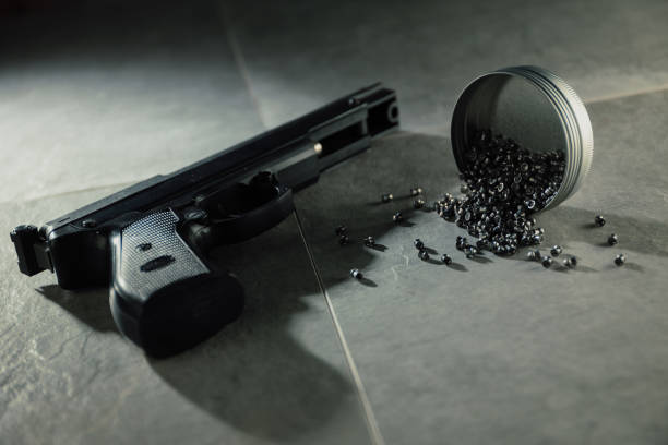 Air gun and pellets on concrete surface.