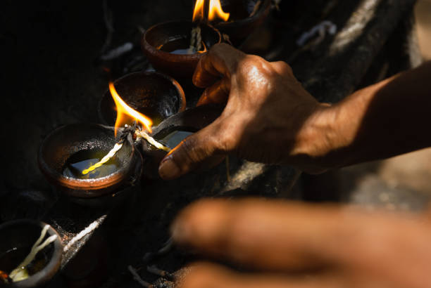 istock Female hands lighting traditional buddhist oil lamps 1412376876