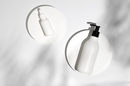 Cosmetic background for product presentation. Mockup of beauty cosmetic makeup bottles product on white podium with shadow. Blank cosmetics pump dispenser.