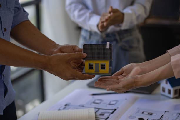 istock Architect engineers shake hands with hats and houses on construction tool tables. with blueprints on the table - business teamwork working together Successful Collaboration Ideas 1412379926