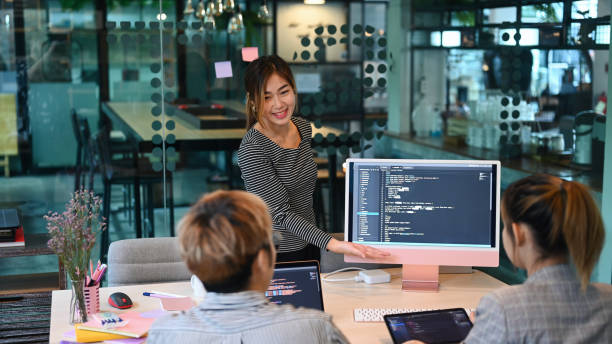 istock Team of IT programmers talking, discussing plan for new project together at modern office. 1412382772
