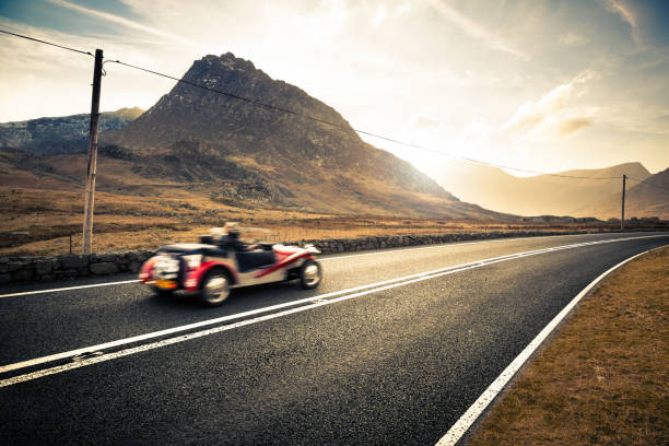Open top classic sports car driving through Snowdonia, Wales, United Kingdom, Europe stock photo