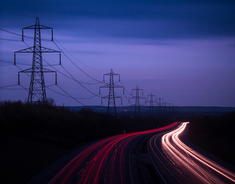 M40 Motorway light trails and power cables at dusk, Oxfordshire, England, United Kingdom, Europe
