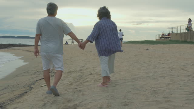 Video footage of Asian senior couple relax and enjoy romantic outdoor holiday vacation with happiness on beach vacation.Senior Adult, Happiness,Elderly, Vacations, Relationship,Healthy care concept.