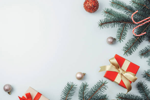 istock Christmas decorations, gift boxes, fir branches and candy cane on light background. Top view, flat lay, copy space 1412386931