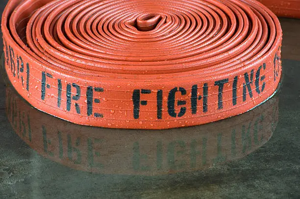 A rolled up firehose on the wet floor in a firestation used by firefighters