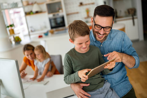 père et enfant utilisant une tablette numérique pour l’apprentissage en ligne. éducation à domicile appareil numérique concept d’enfant. - home schooling photos et images de collection