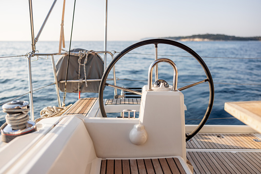 Regatta sailing ship yachts with white sails at opened sea. Aerial view of sailboat in windy condition.