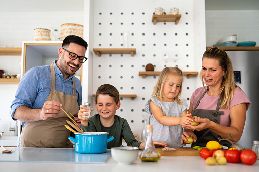 Happy family having fun preparing healthy food together in kitchen