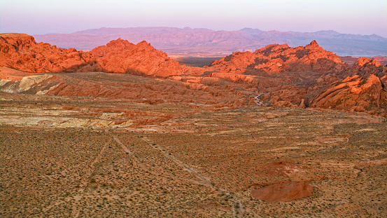 Aerial view of red mountains and cliffs of valley of fire at sunset, Nevada, USA.