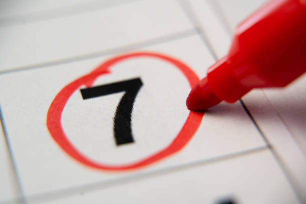 The calendar 7st day of the month is circled. A red marker circles the first day of the paper calendar. A very important date in the calendar. stock photo