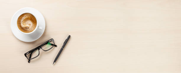 istock Office desk with coffee, pen and glasses 1412393448