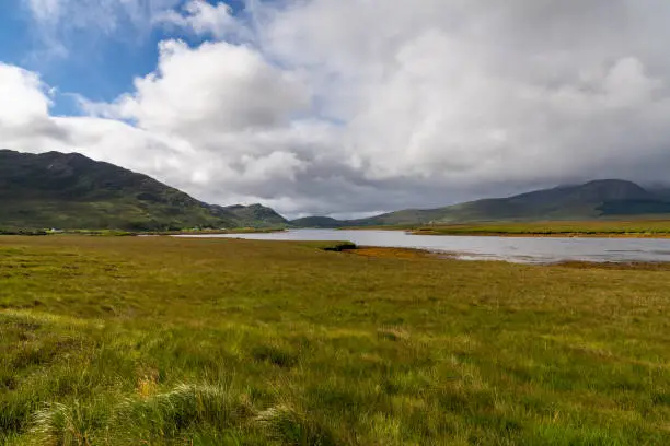 A bog and lake landscape in Ballycroy National Park with the Nephin mountain range in the back