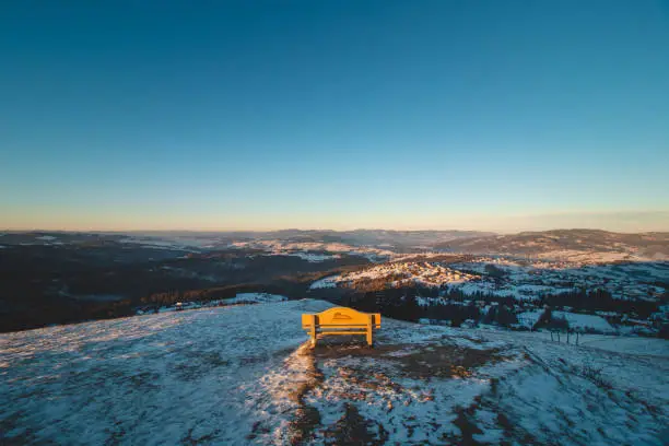Bench on Mount Ochodzita in the Koniakow area of the Polish Beskydy Mountains illuminated in the morning light. Beautiful quiet resting place.