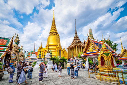 Bangkok, Thailand - September 9, 2019: tourists visitin the Grand Palace Wat Phra Kaew Ancient temple in bangkok on the beautiful cloudy blue sky