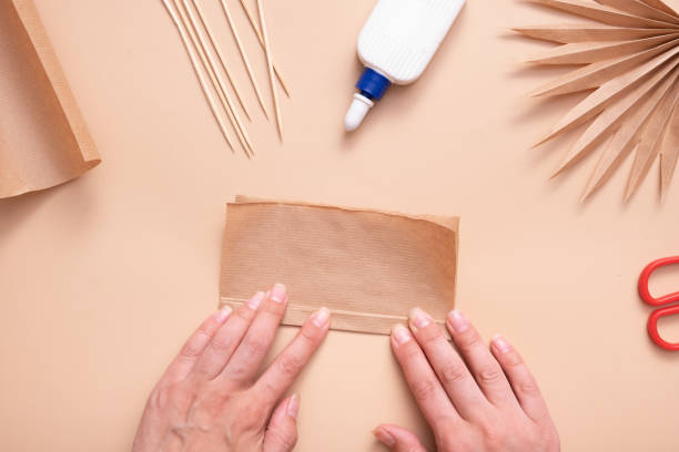 istock Assembling a paper blank with an accordion. Creative handwork to create tropical leaves. Master class 1412399732