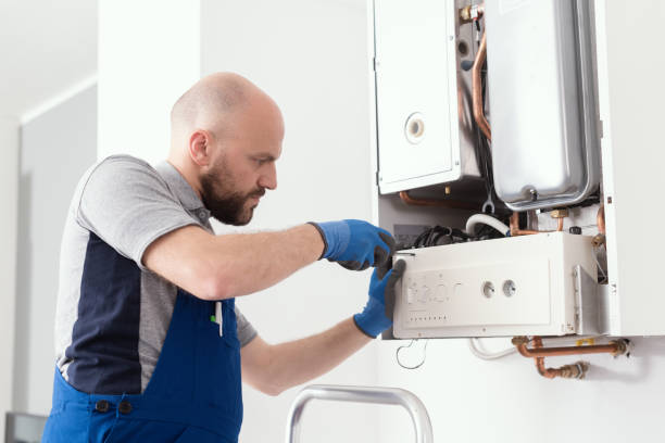 Professional engineer servicing a boiler at home Professional boiler service: qualified technician checking a natural gas boiler at home heating engineer stock pictures, royalty-free photos & images