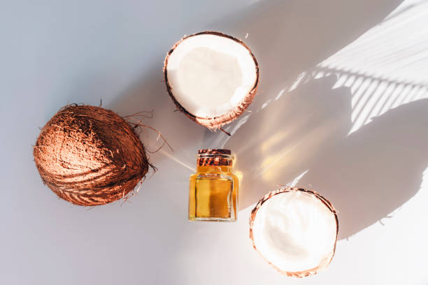 ヤシの葉の影の白い背景にココナッツオイルと新鮮なココナッツ。代替療法の概念。トップビュー、フラットレイ - aromatherapy oil massage oil alternative therapy massaging ストックフォトと画像