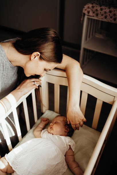 istock Baby sleeps with mather 1412403142