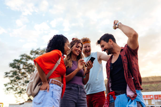 istock Four festival people using phone 1412406496