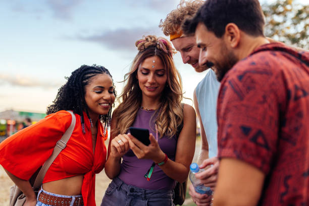 istock Four festival people using phone 1412406505
