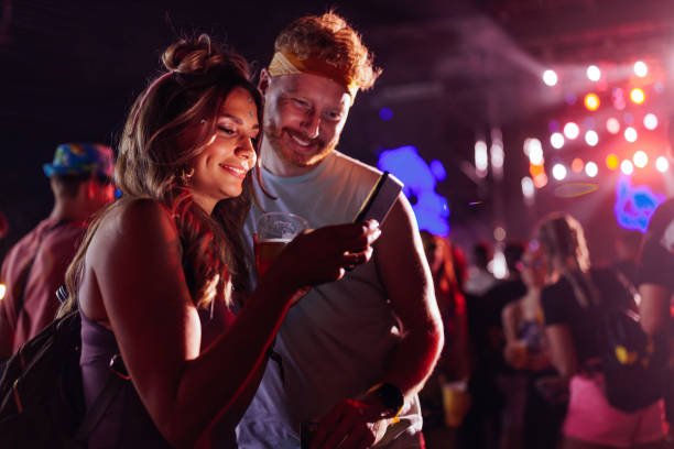 istock Couple using cellphone at music festival 1412406528