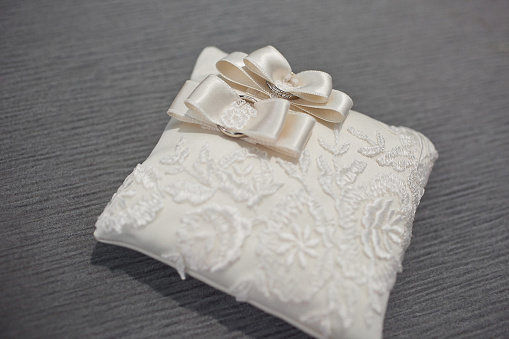 Two wedding rings on a lace pillow.