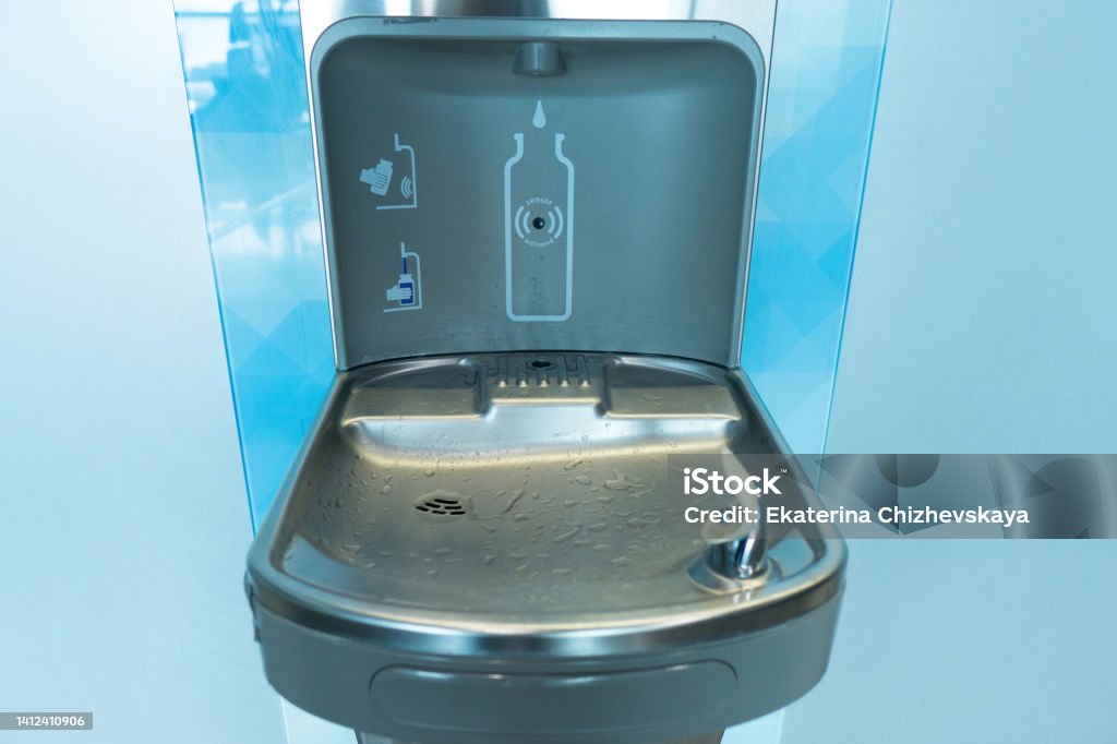 Modern drinking water fountain at the airport Close-up of a modern drinking fountain and bottle filling station at the airport Refill Stock Photo