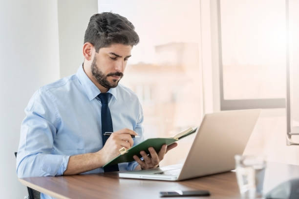 istock Businessman using laptop while sitting at desk and working at the office 1412413716
